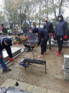 Wychowankowie porządkują groby na cmentarzu
