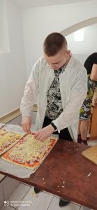 Wychowanek przygotowuje ciasto na pizzę