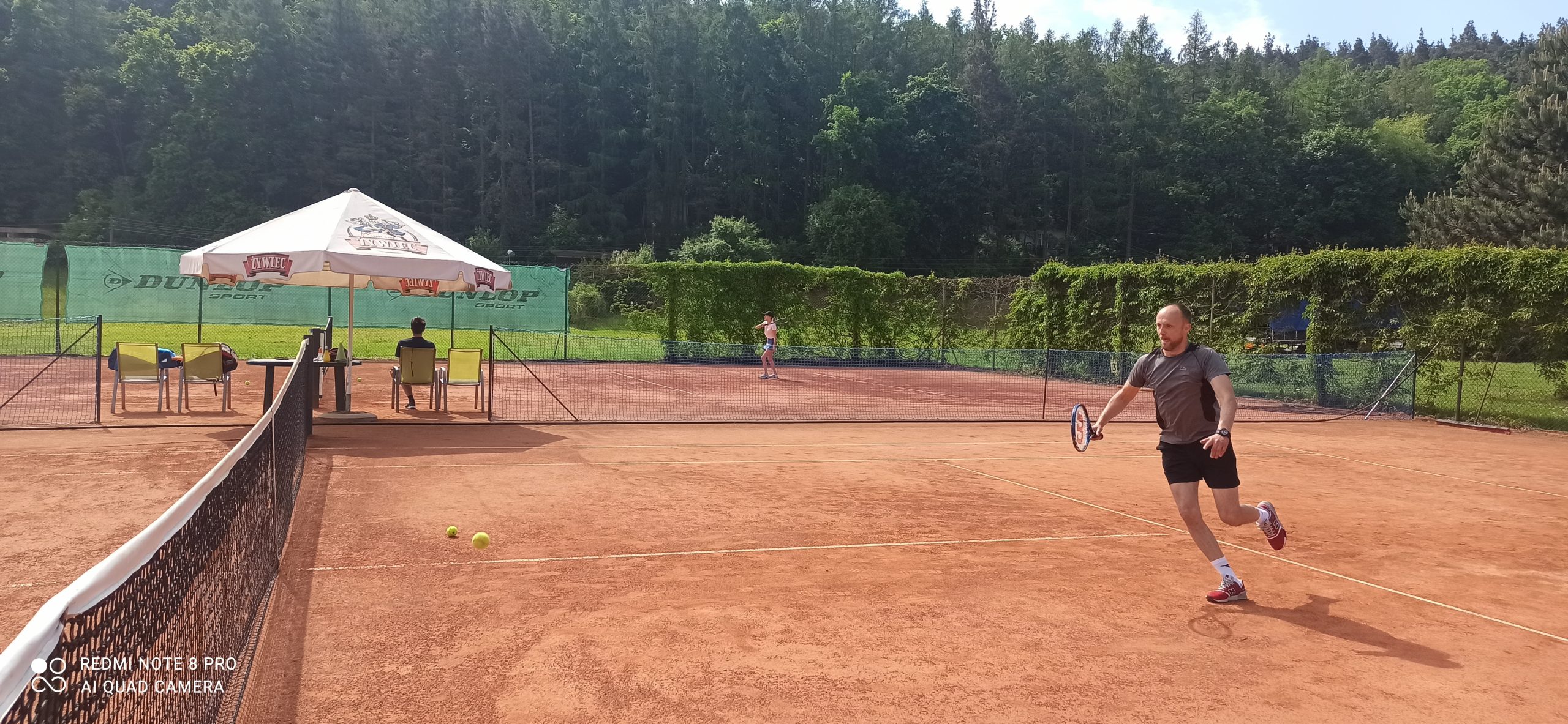 Wychowawca gra w tenisa ziemnego na korcie