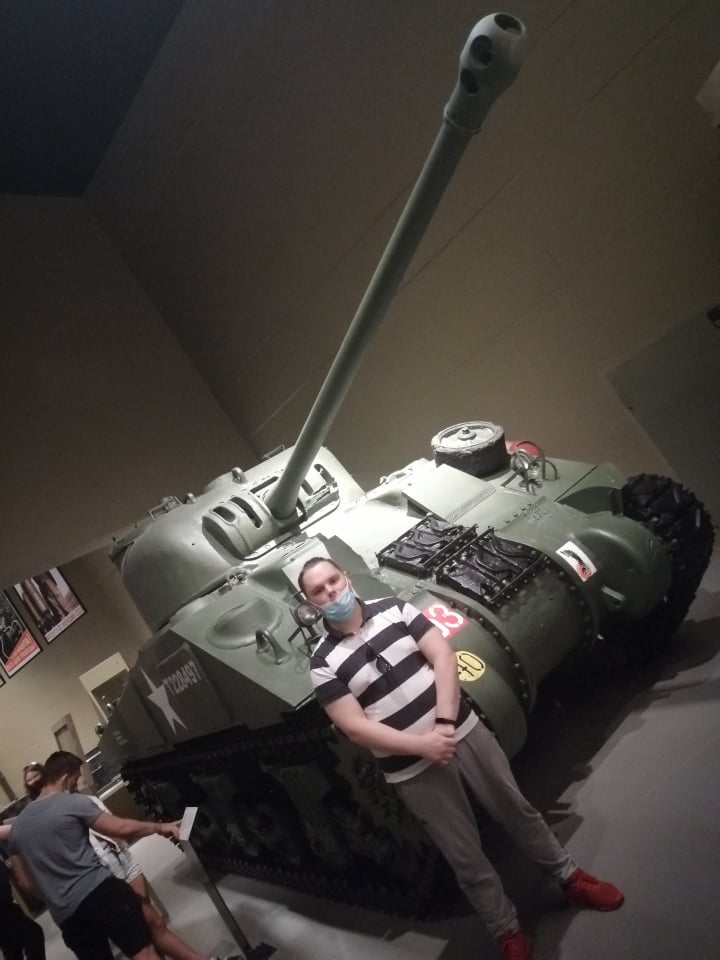 Wychowanek stoi przy czołgu