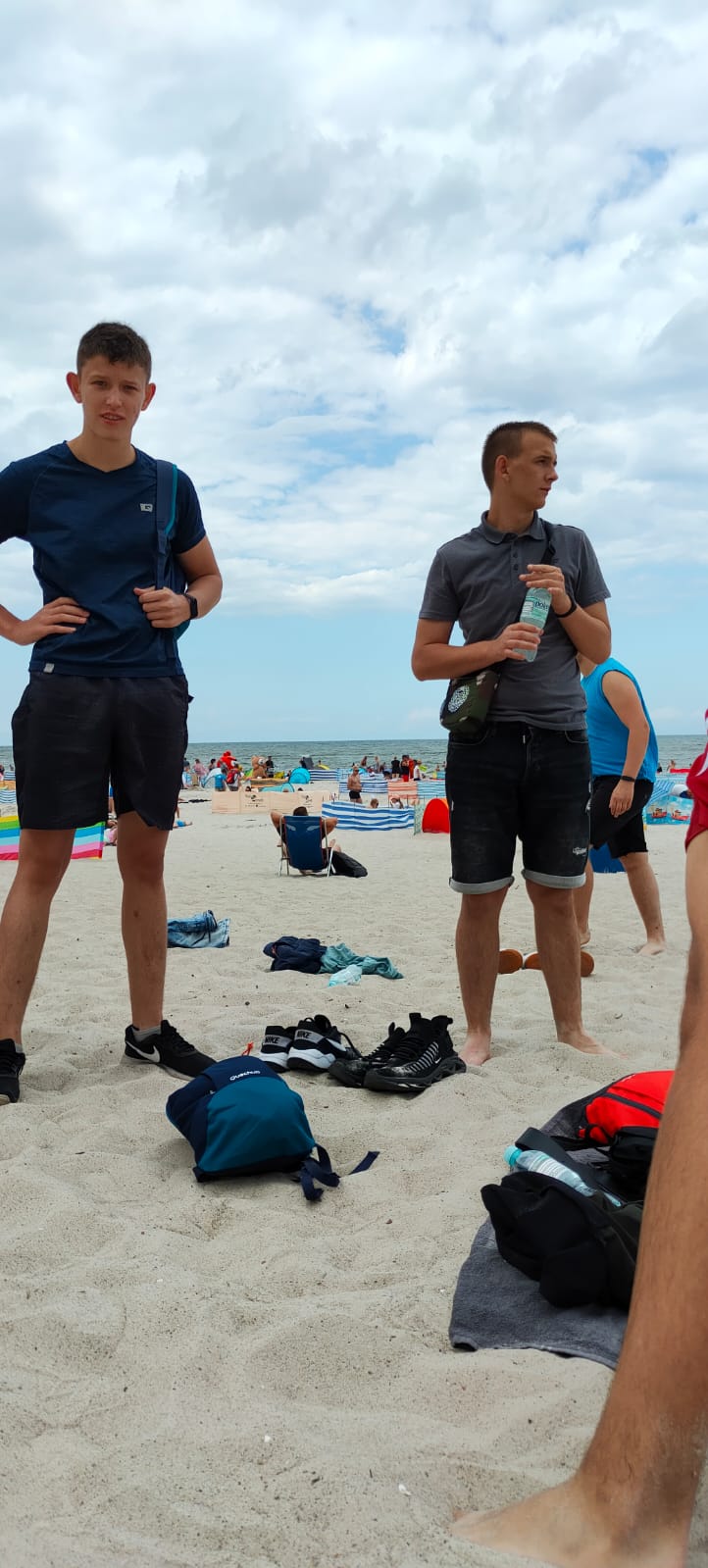 Dwóch wychowanków stoi  na plaży