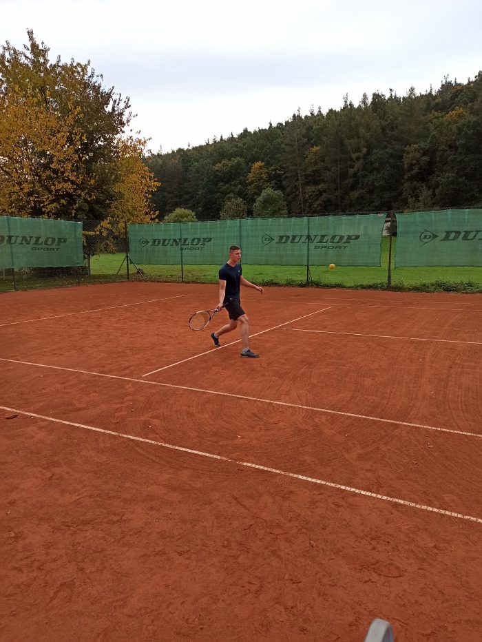 Wychowanek gra w tenisa ziemnego na korcie